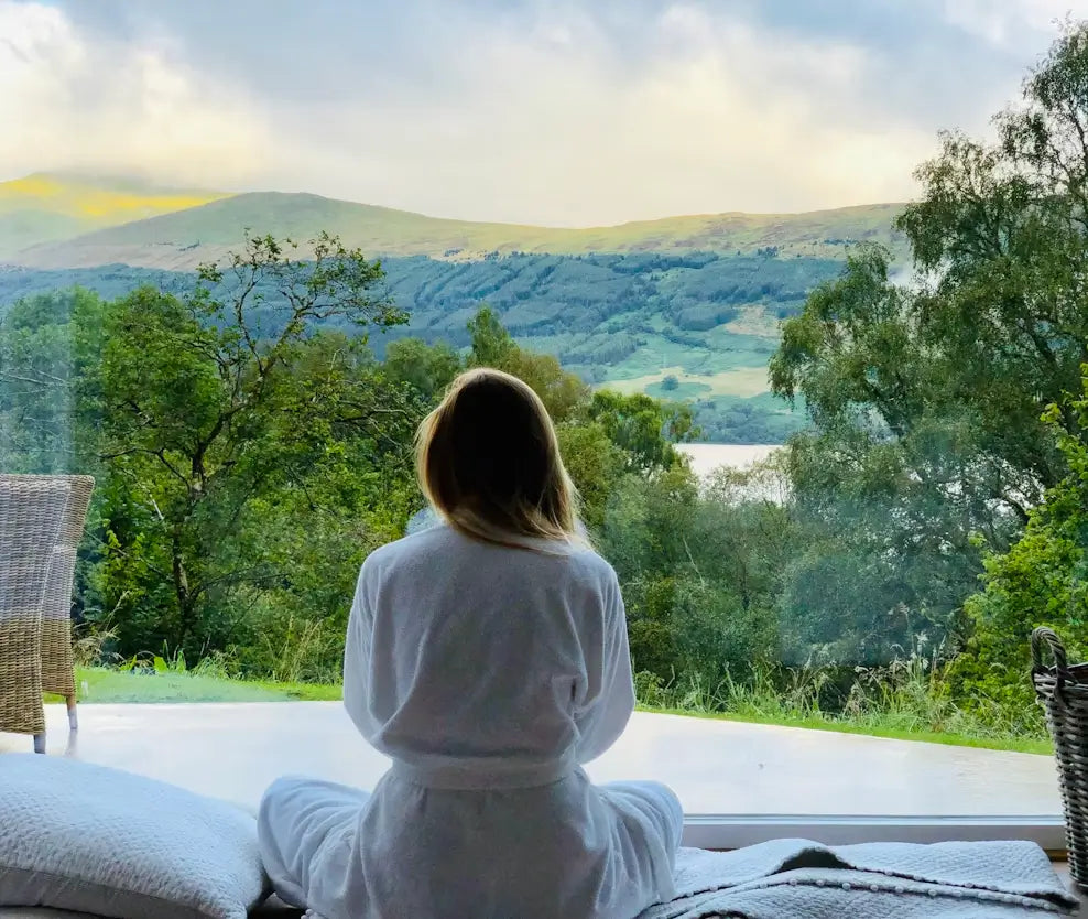 Woman in white robe sitting in a meditative state and practicing the 3-3-3 rule for anxiety.