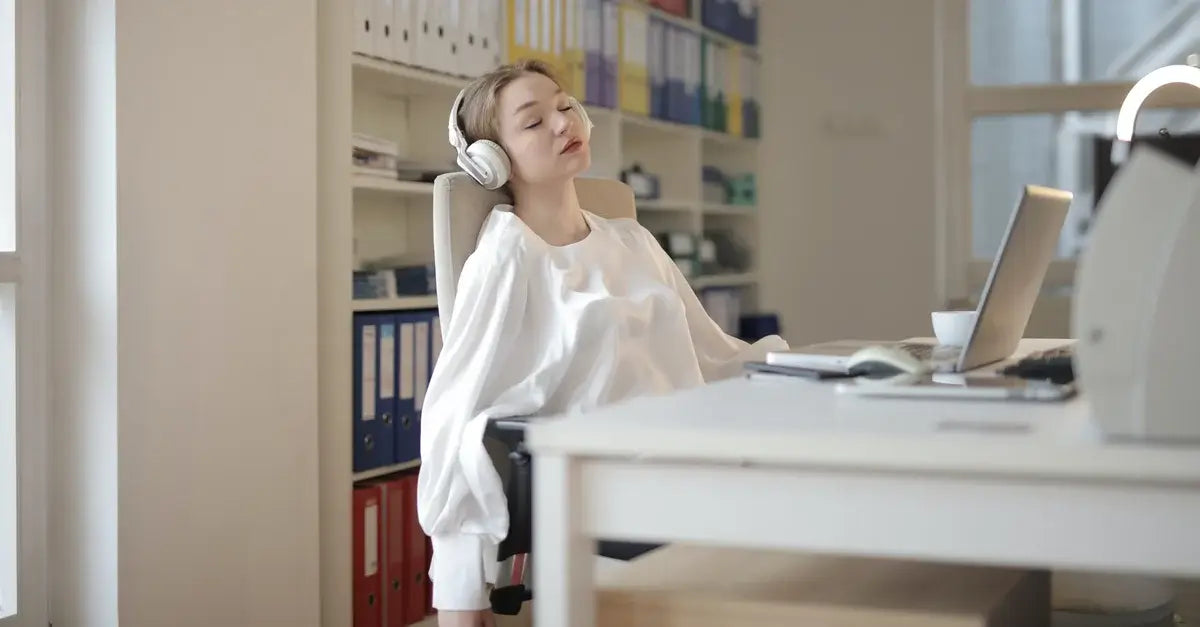 Woman with ADHD taking a break at work, eyes closed.
