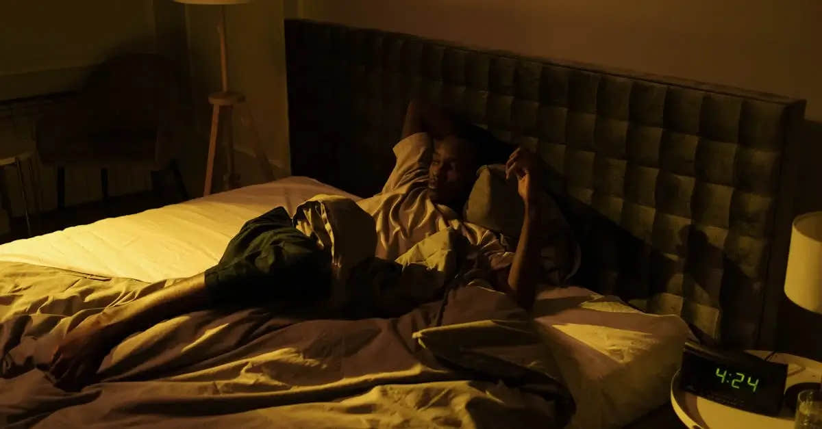 Man lying awake in bed late night, looking restless.