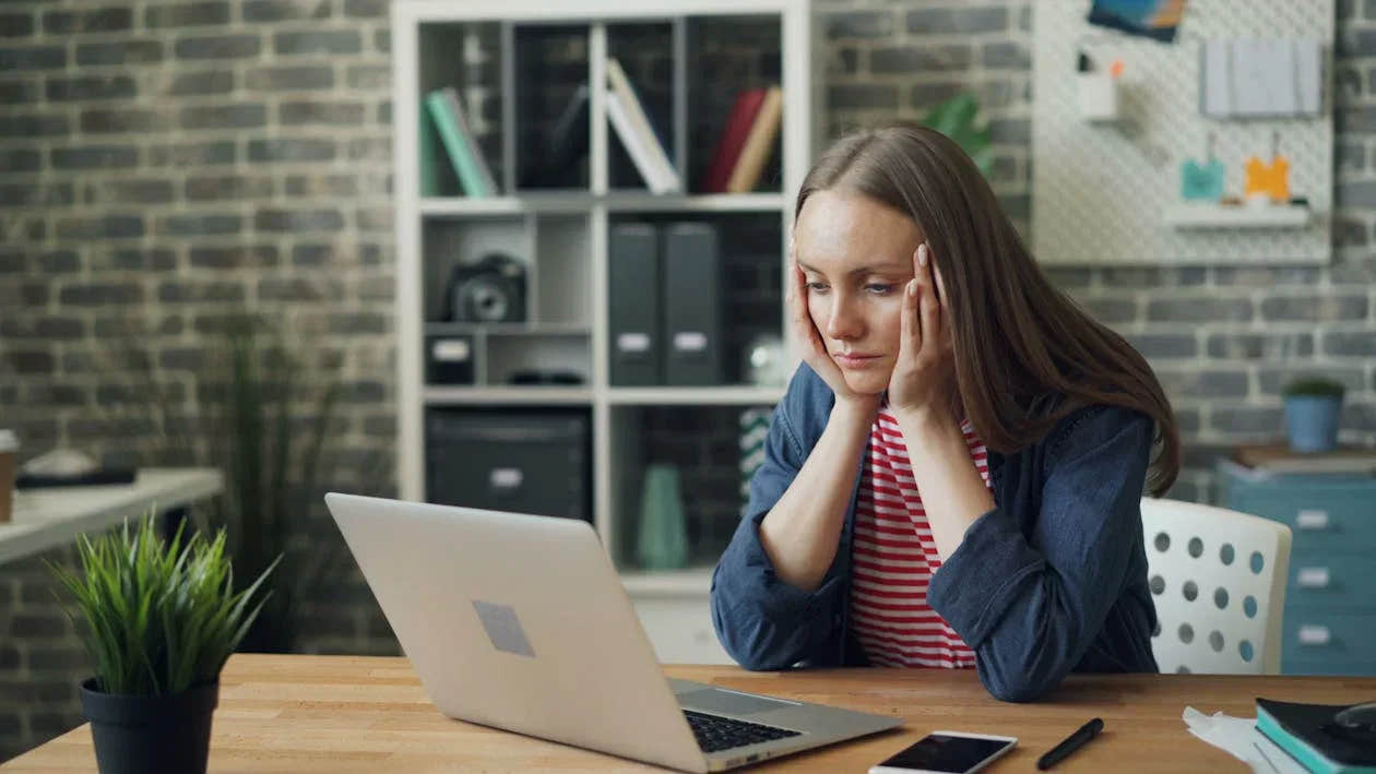 A stressed woman staring at her laptop.