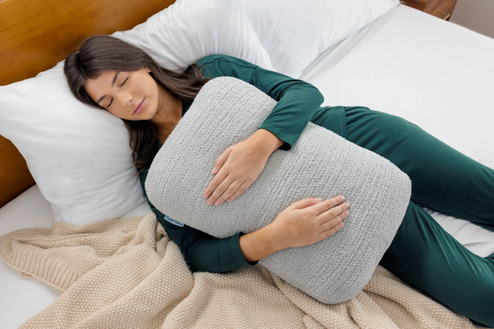 One Quiet Mind weighted body pillow hugged in bed for gentle, cozy sleep support.