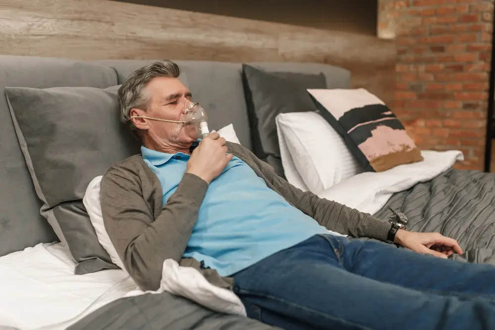 Man lying in bed using an CPAP mask.