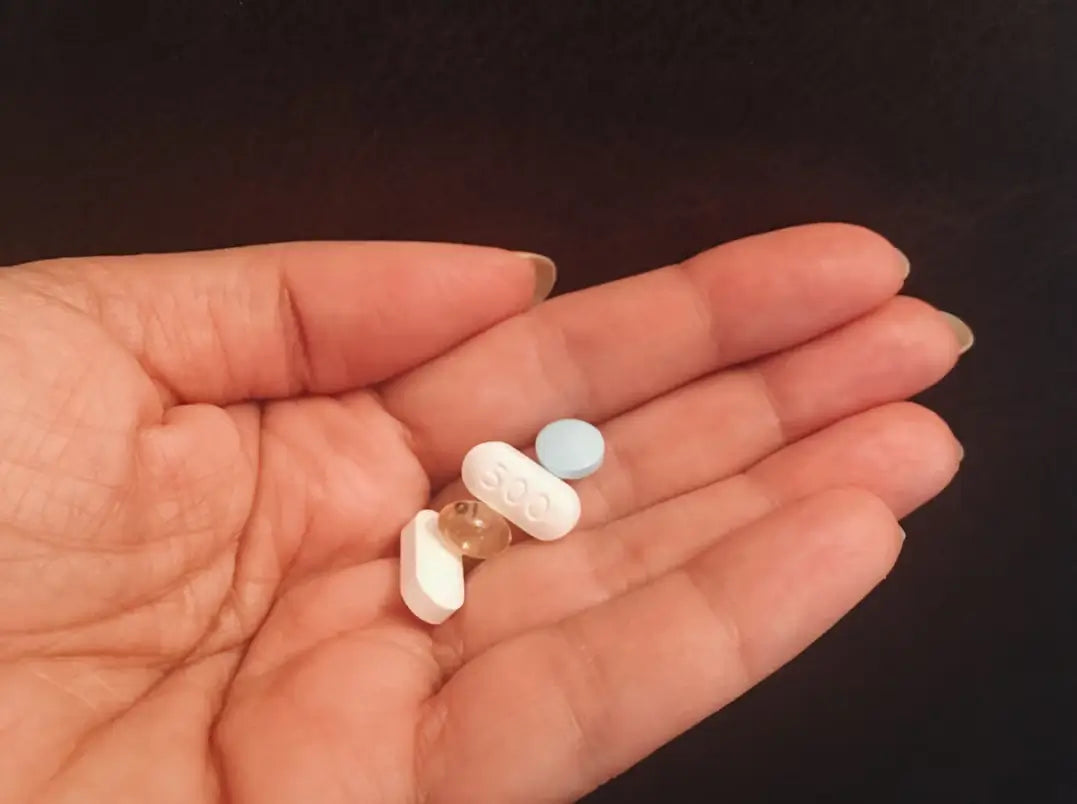 Close-up of a hand holding vitamin pills for anxiety relief.