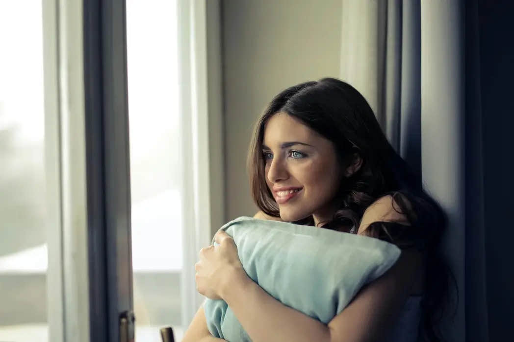Woman comfortably holding a weighted pillow for calm.