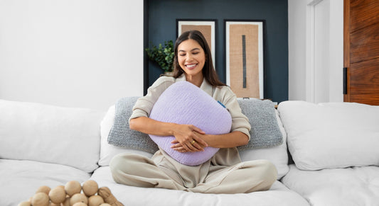 One Quiet Mind weighted pillow held on a white couch during a cozy calm-down moment.
